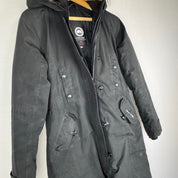 Canada Goose black parka jacket with logo patch and fur-lined hood.
