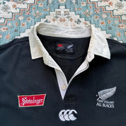 Canterbury men's polo shirt black with All Blacks logo and rugby pattern details.