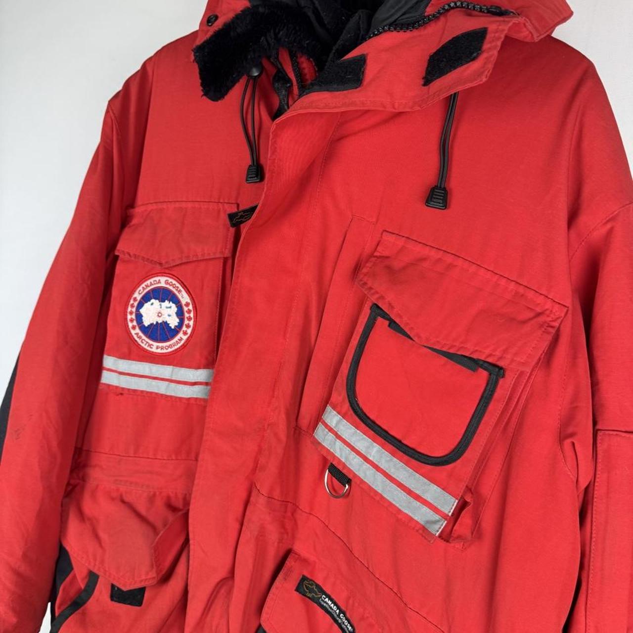 Canada Goose red parka jacket with logo patch and thick insulated material.
