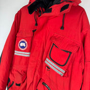 Canada Goose red parka jacket with logo patch and thick insulated material.
