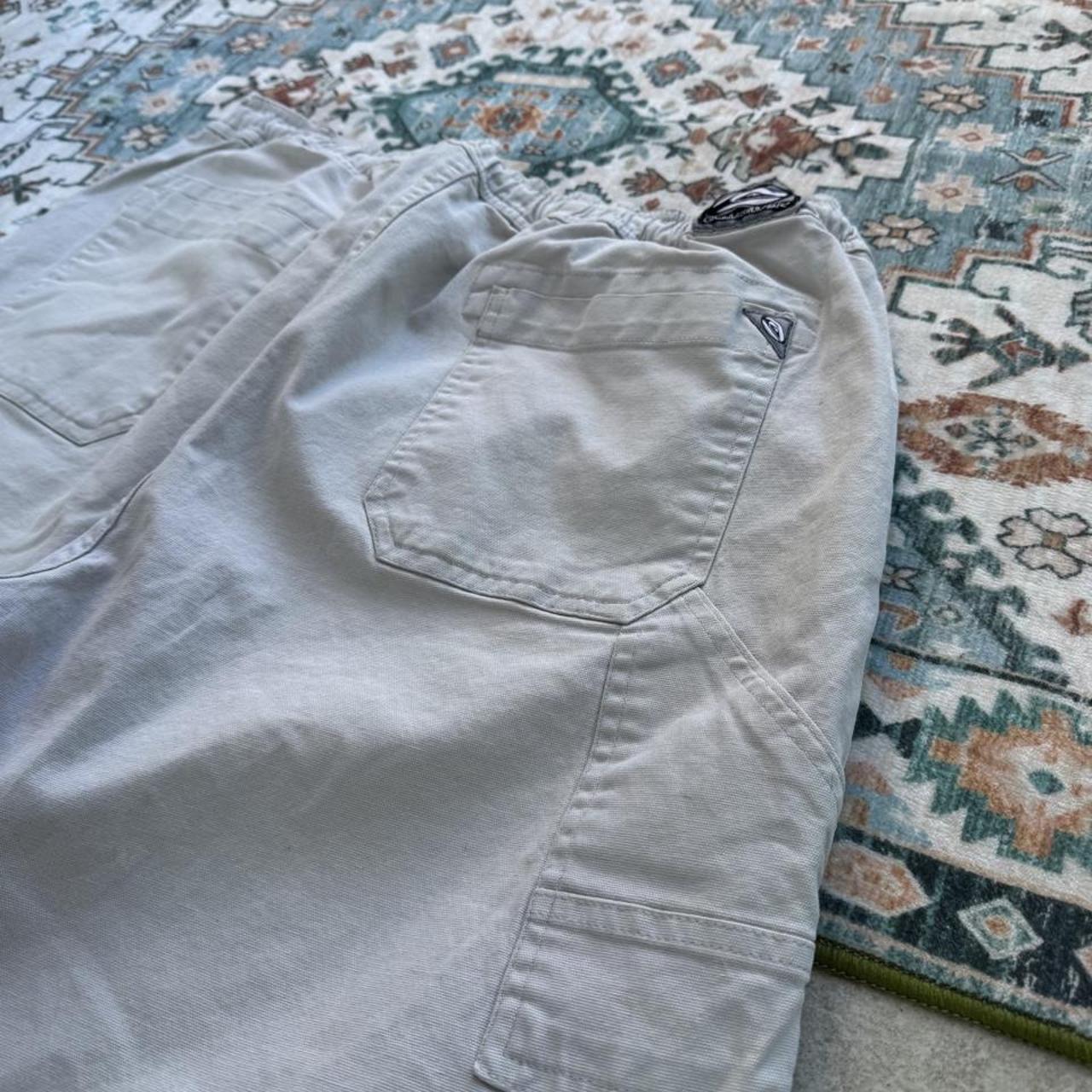 Quiksilver cream cargo shorts with embroidered logo and front pockets.
