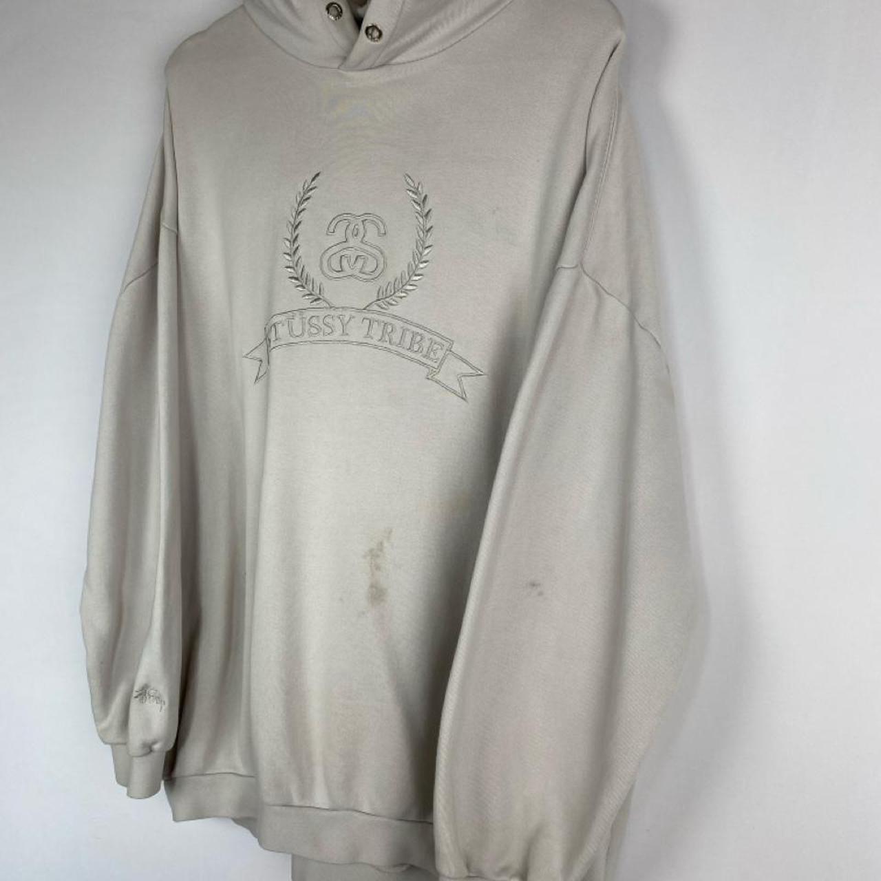 Stüssy cream hoodie with embroidered spellout logo and oversized fit.