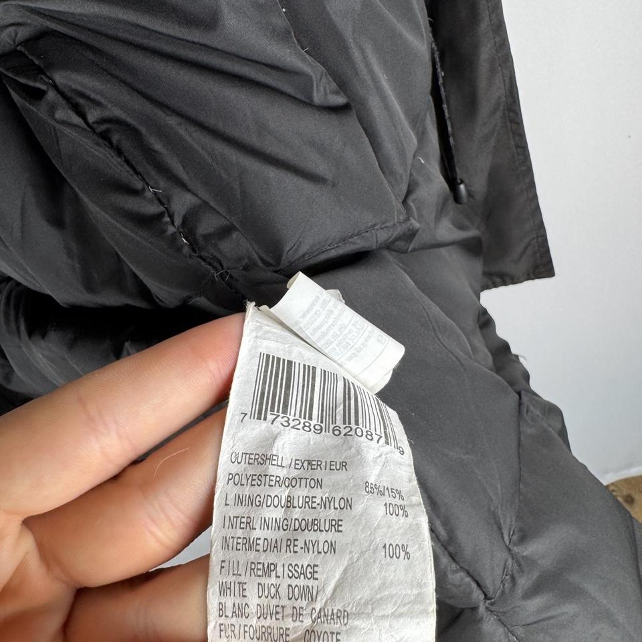 Canada Goose black parka jacket with logo, slight tear near pocket, missing hood.