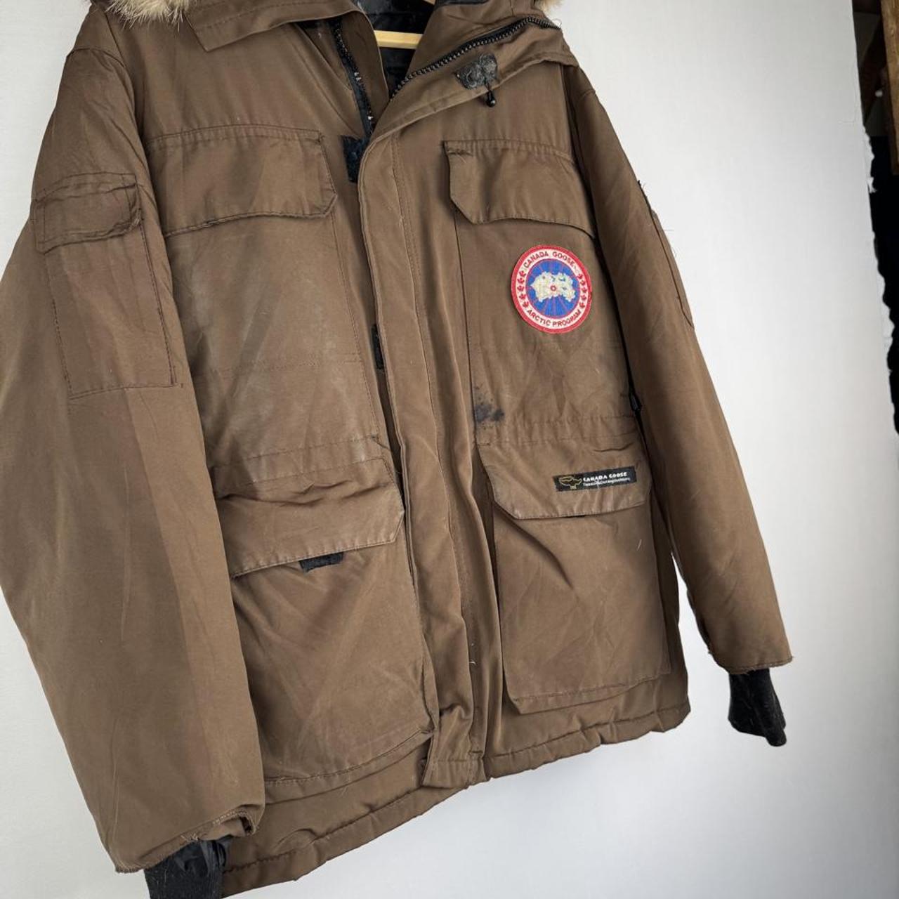 Canada Goose brown parka jacket with logo patch and utility pockets.