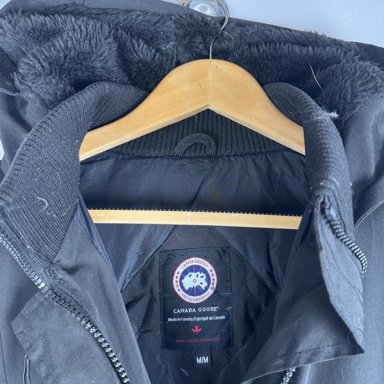 Canada Goose black parka jacket, medium size, features logo patch and sleek design.