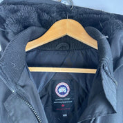 Canada Goose black parka jacket, medium size, features logo patch and sleek design.