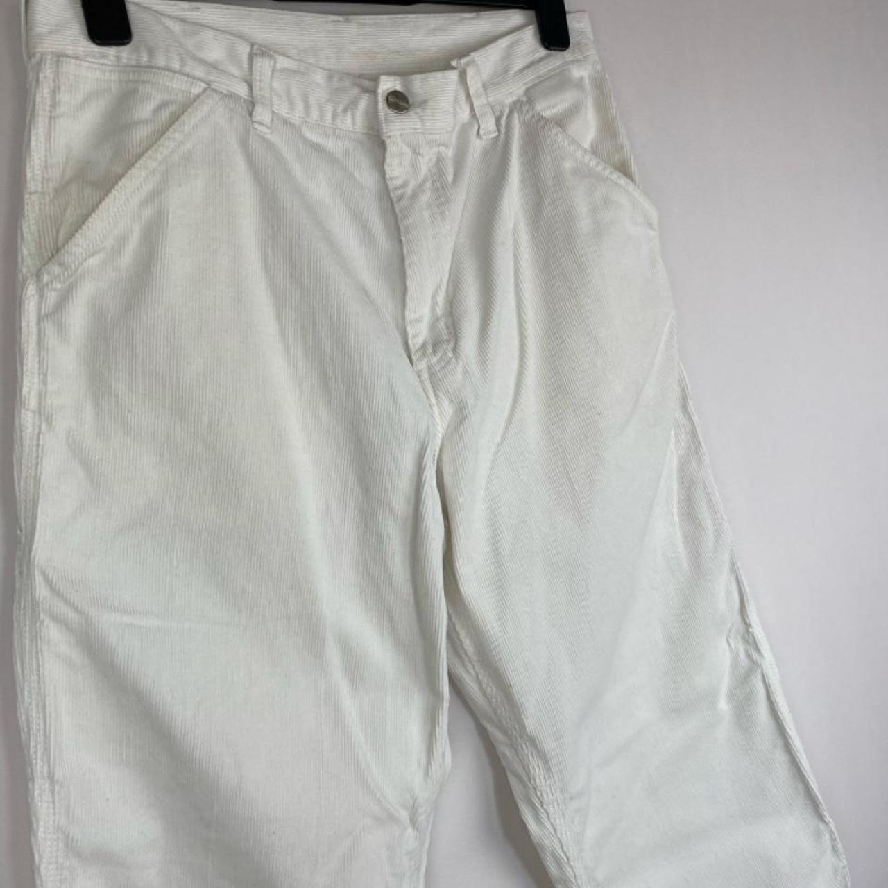 Carhartt WIP white corduroy carpenter trousers with single knee design and relaxed fit.