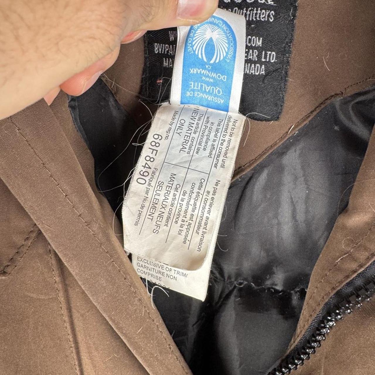 Canada Goose brown parka jacket with logo patch and utility pockets.