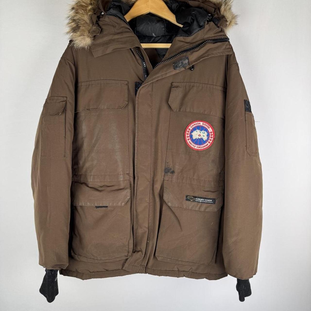 Canada Goose brown parka jacket with logo patch and utility pockets.