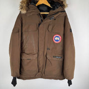 Canada Goose brown parka jacket with logo patch and utility pockets.