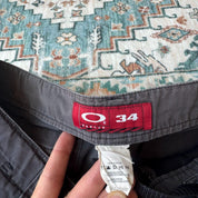 Oakley black cargo shorts with embroidered logo and tactical pockets.
