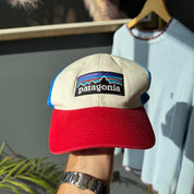 Patagonia cream trucker cap with embroidered logo and mesh back.