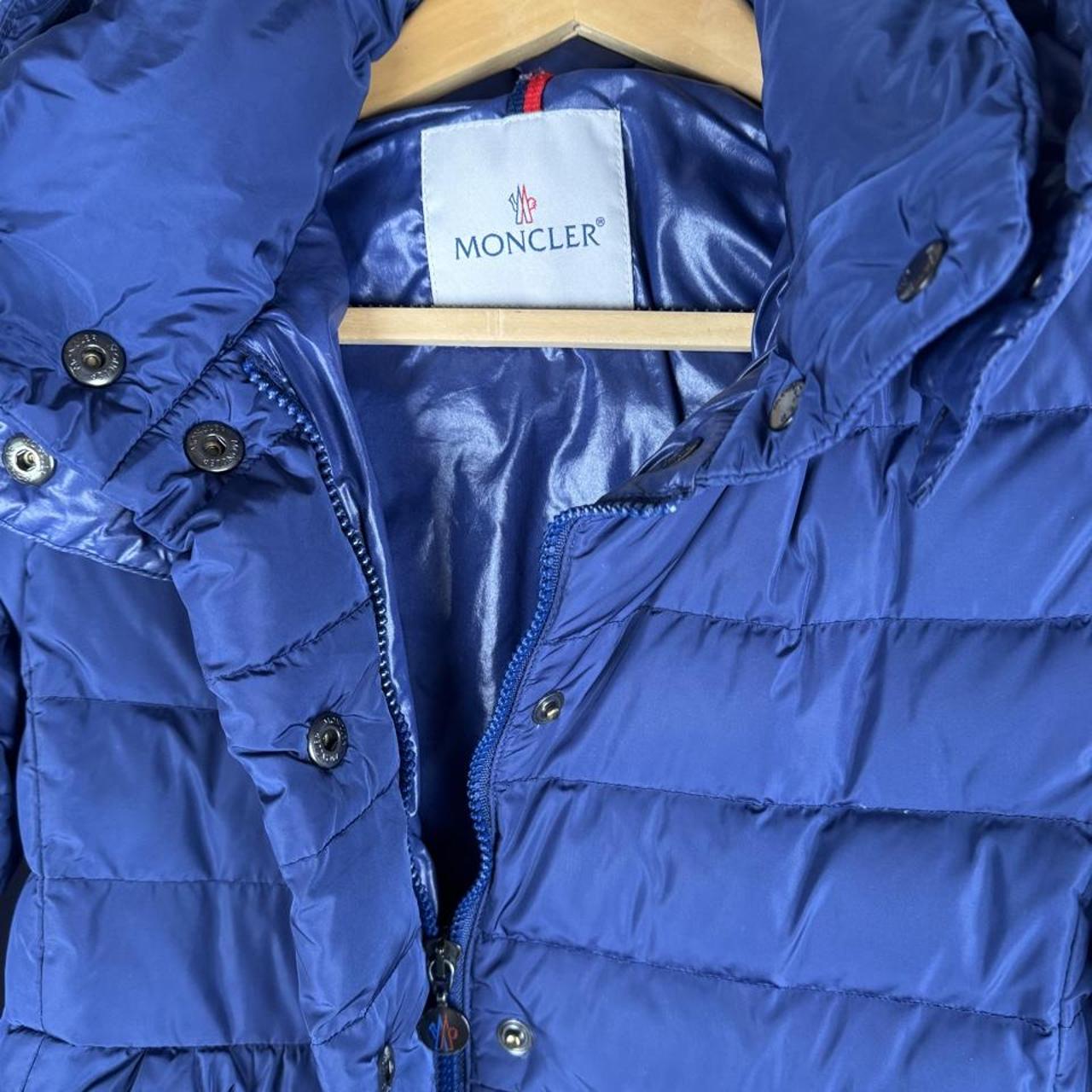 Moncler blue puffer jacket with logo detail and quilted design.