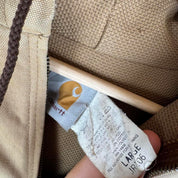 Carhartt cream distressed active jacket with logo patch and relaxed fit.