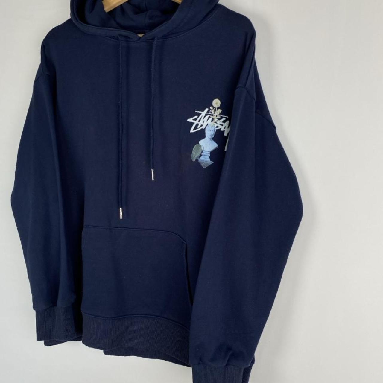 Stüssy black hoodie with stone statue graphic and logo print.