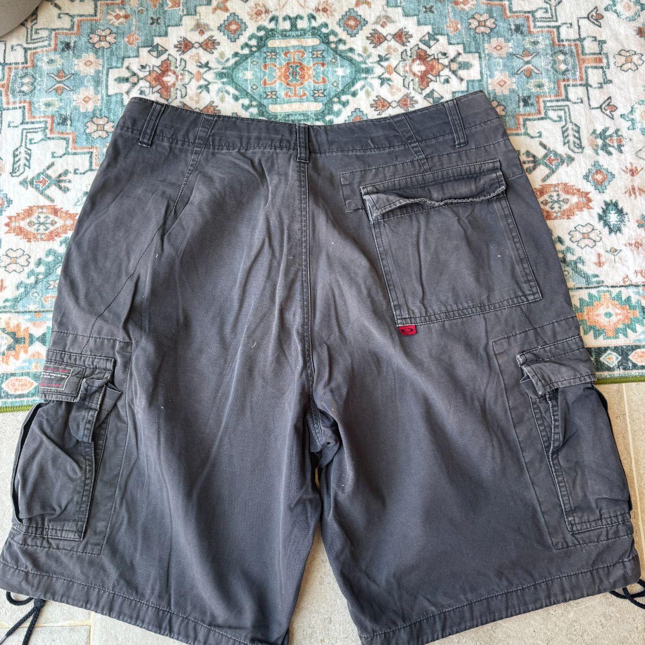 Oakley black cargo shorts with embroidered logo and tactical pockets.