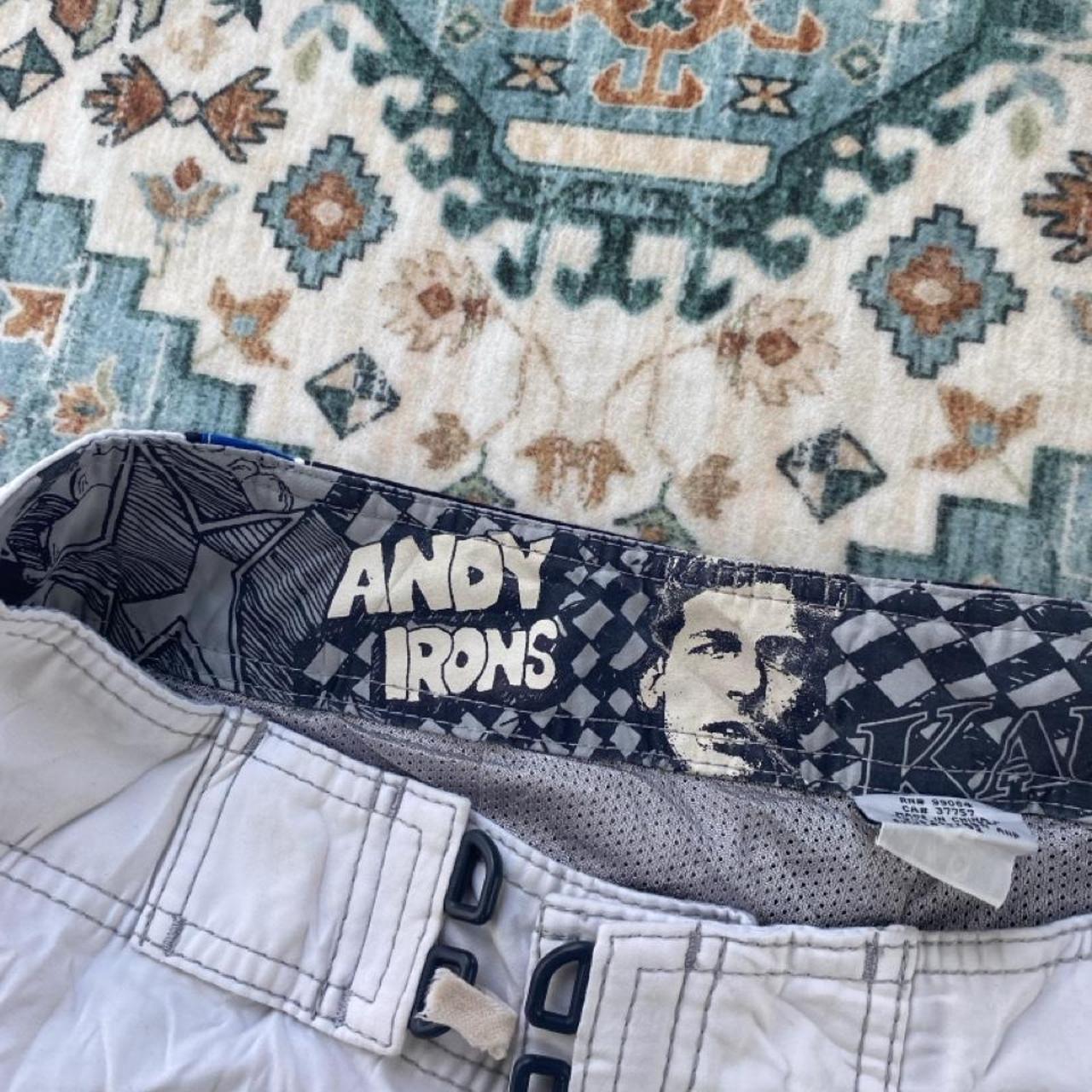 Billabong board shorts blue with tropical print and Andy Irons logo detail.