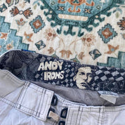Billabong board shorts blue with tropical print and Andy Irons logo detail.
