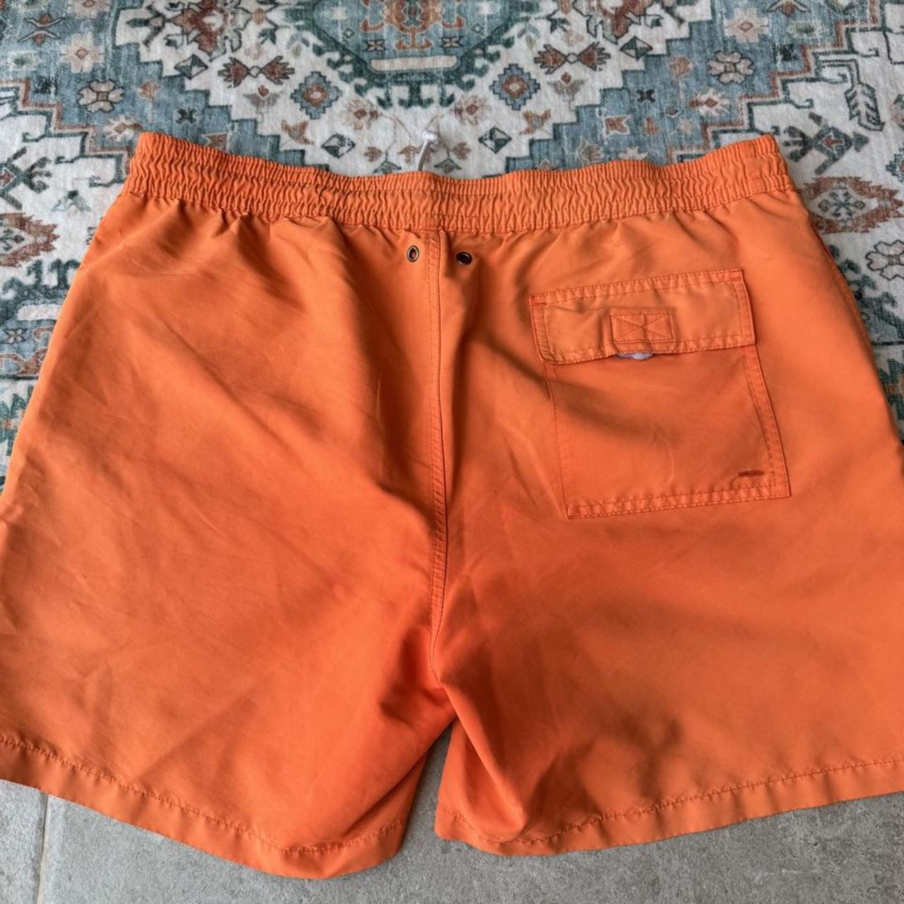 Polo Ralph Lauren orange swim trunks with iconic embroidered logo and lightweight fabric.