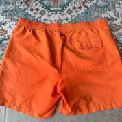 Polo Ralph Lauren orange swim trunks with iconic embroidered logo and lightweight fabric.