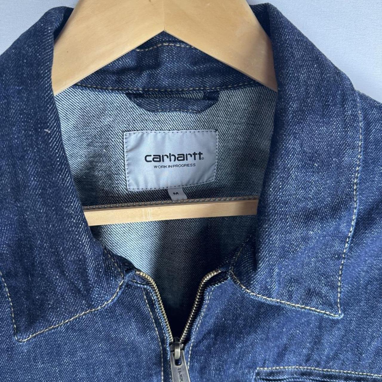 Carhartt WIP blue denim jacket with logo patch and classic design details.