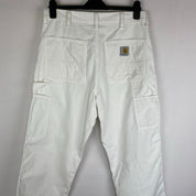 Carhartt WIP white corduroy carpenter trousers with single knee design and relaxed fit.