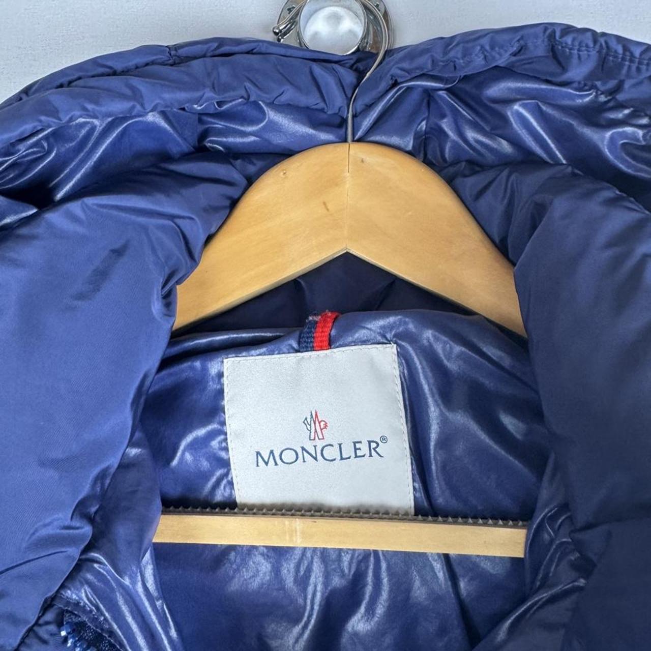 Moncler blue puffer jacket with logo detail and quilted design.