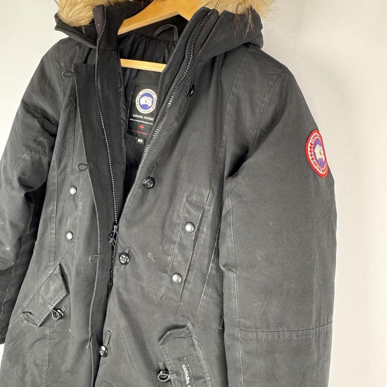Canada Goose black parka jacket with logo patch and fur-lined hood.