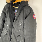 Canada Goose black parka jacket with logo patch and fur-lined hood.