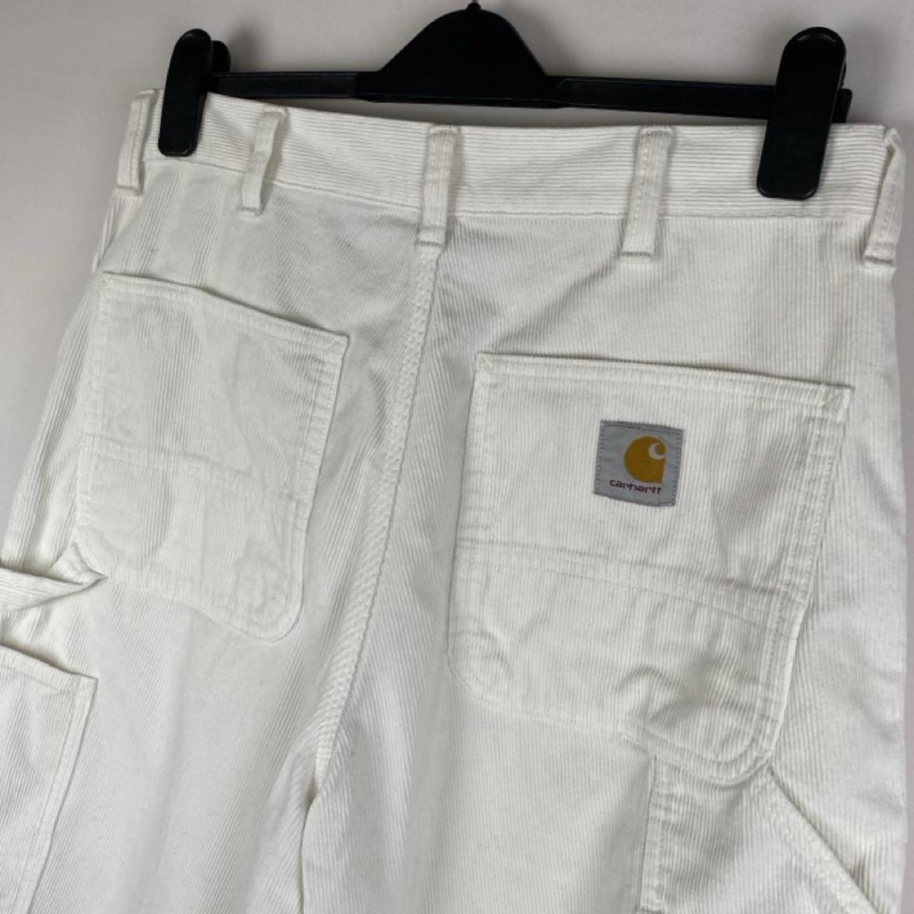 Carhartt WIP white corduroy carpenter trousers with single knee design and relaxed fit.