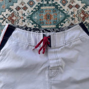Billabong board shorts blue with embroidered Taj Burrow signature and tropical pattern.