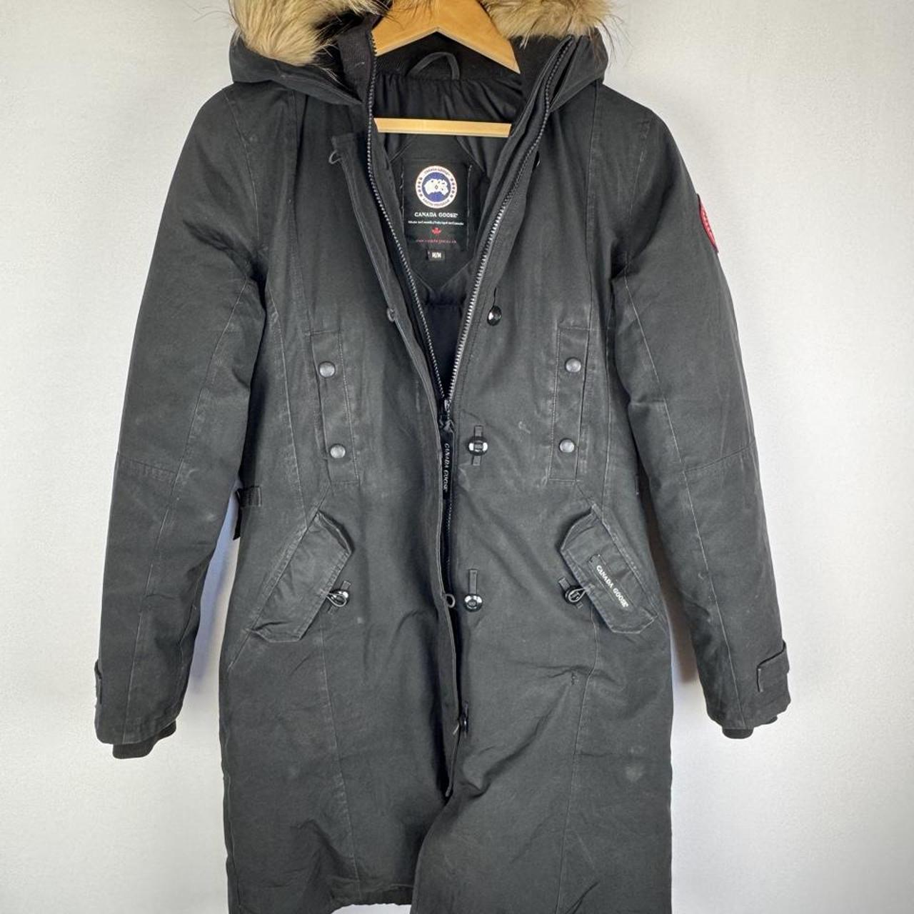 Canada Goose black parka jacket with logo patch and fur-lined hood.