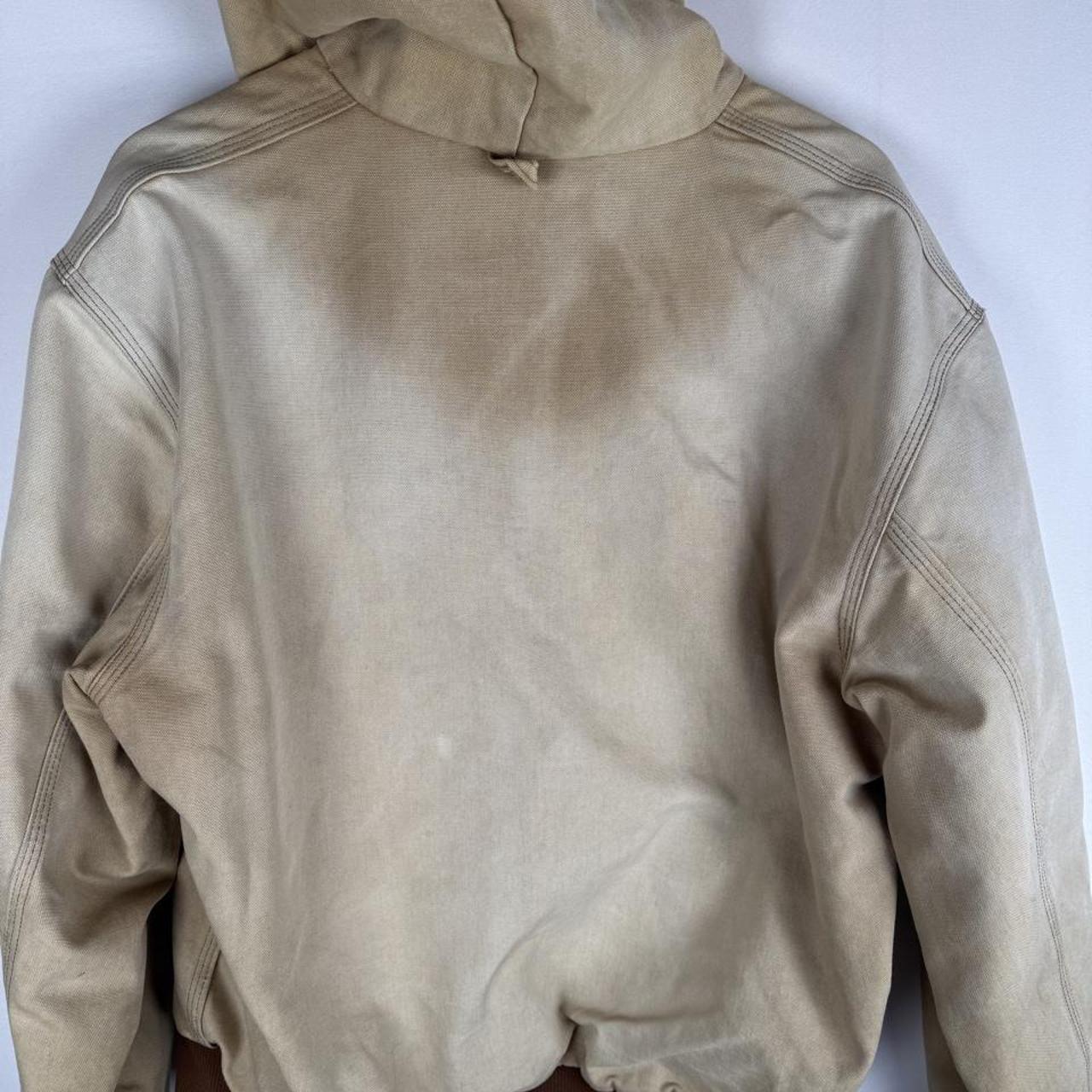 Carhartt cream distressed active jacket with logo patch and relaxed fit.
