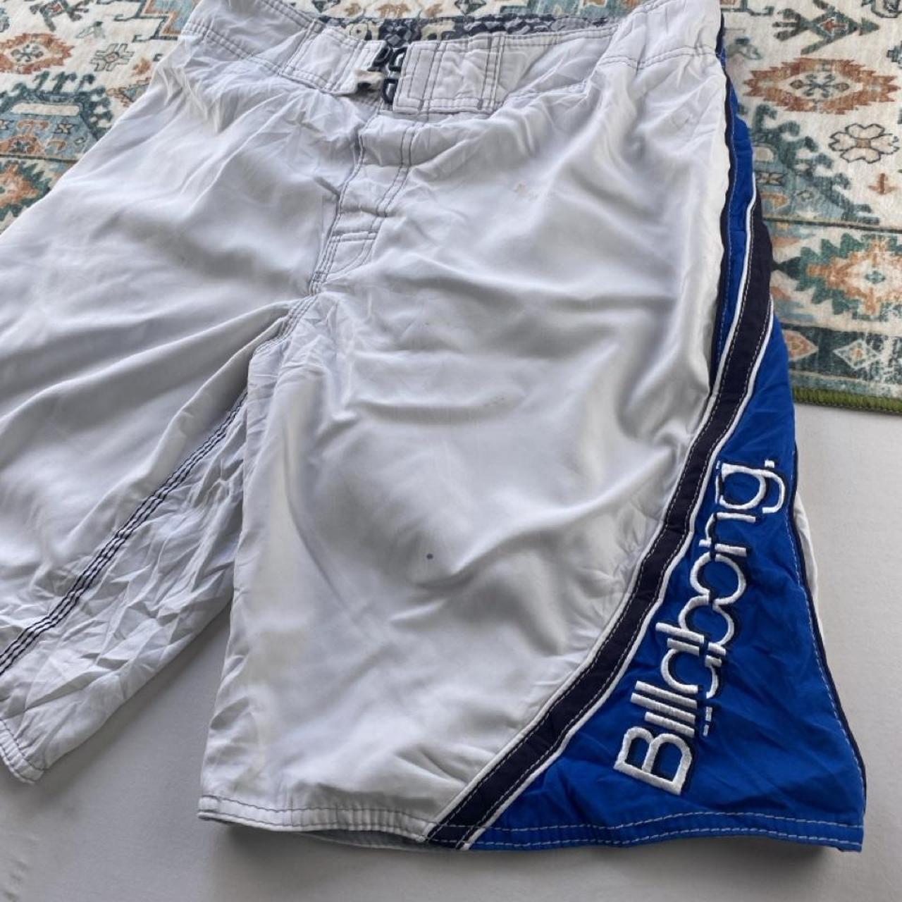 Billabong board shorts blue with tropical print and Andy Irons logo detail.