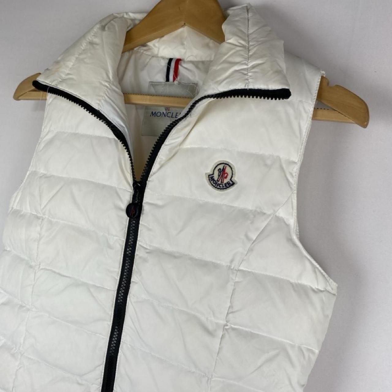 Moncler white down puffer gilet with logo detail and missing belt.