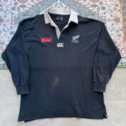 Canterbury men's polo shirt black with All Blacks logo and rugby pattern details.