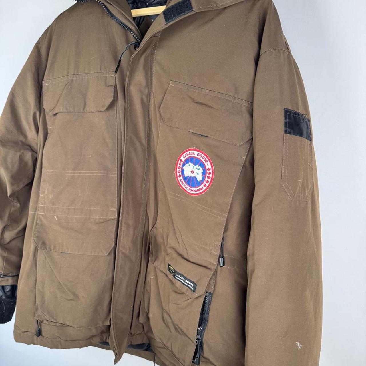 Canada Goose brown parka jacket with utility pockets and logo patch.