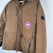 Canada Goose brown parka jacket with utility pockets and logo patch.