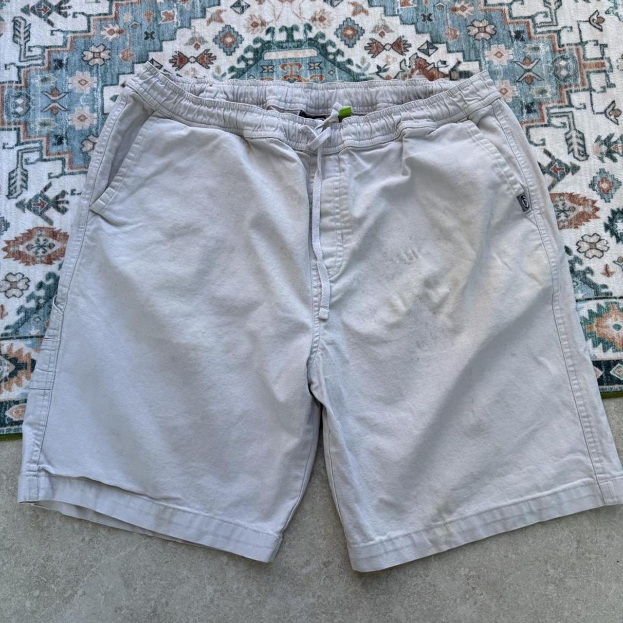 Quiksilver cream cargo shorts with embroidered logo and front pockets.
