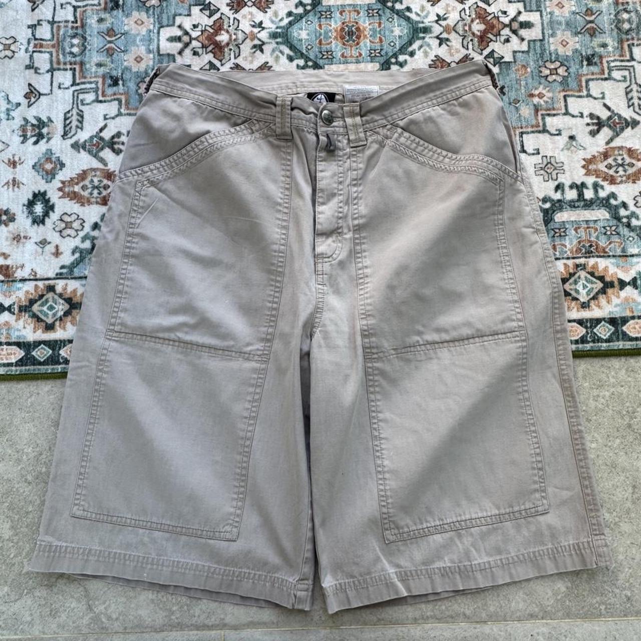 Nike ACG beige cargo pants with embroidered logo and multiple pockets.