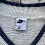 Nike cream knitted v-neck jumper with embroidered logo and visible marks on front.