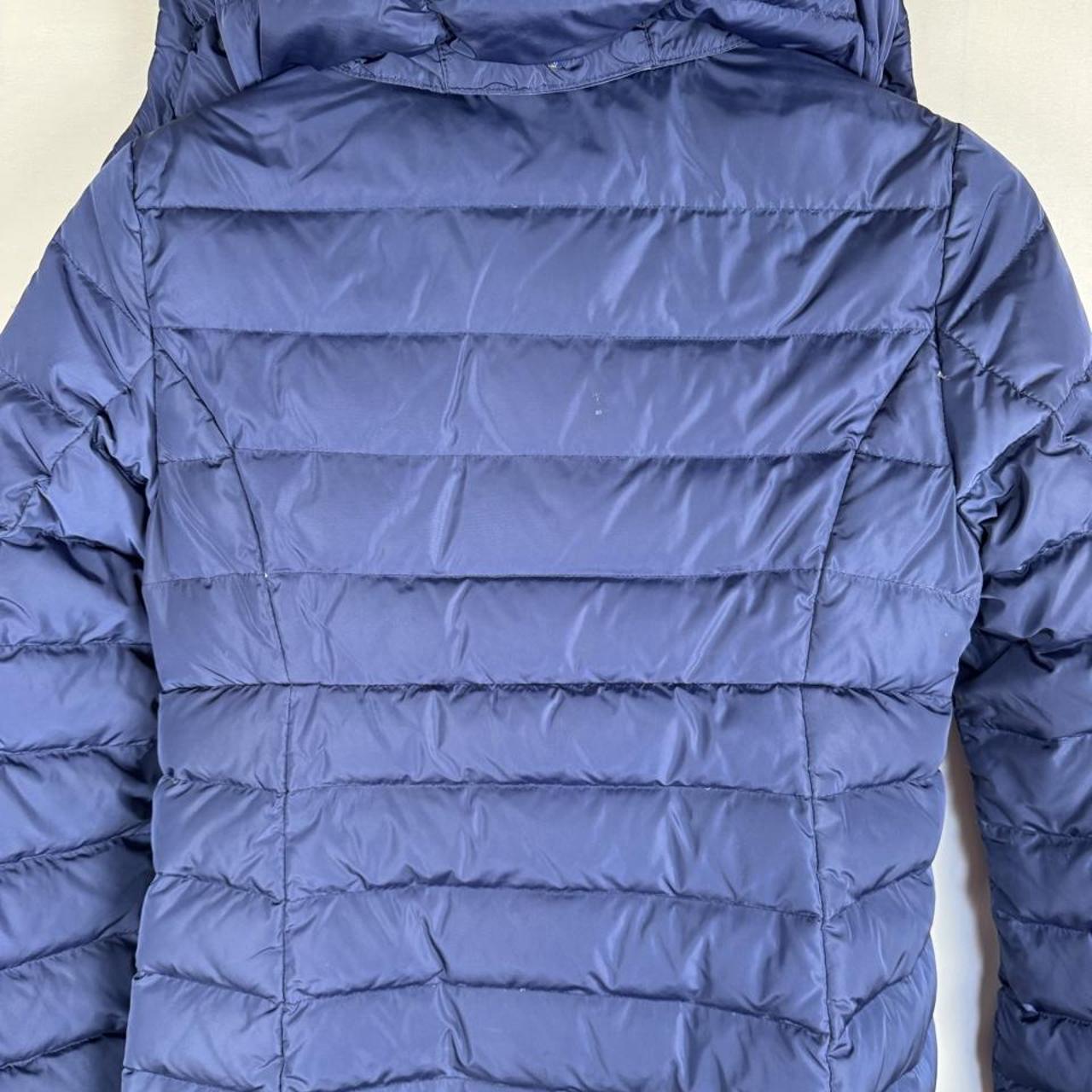 Moncler blue puffer jacket with logo detail and quilted design.