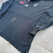 Canterbury men's polo shirt black with All Blacks logo and rugby pattern details.