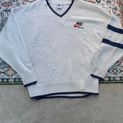 Nike cream knitted v-neck jumper with embroidered logo and visible marks on front.