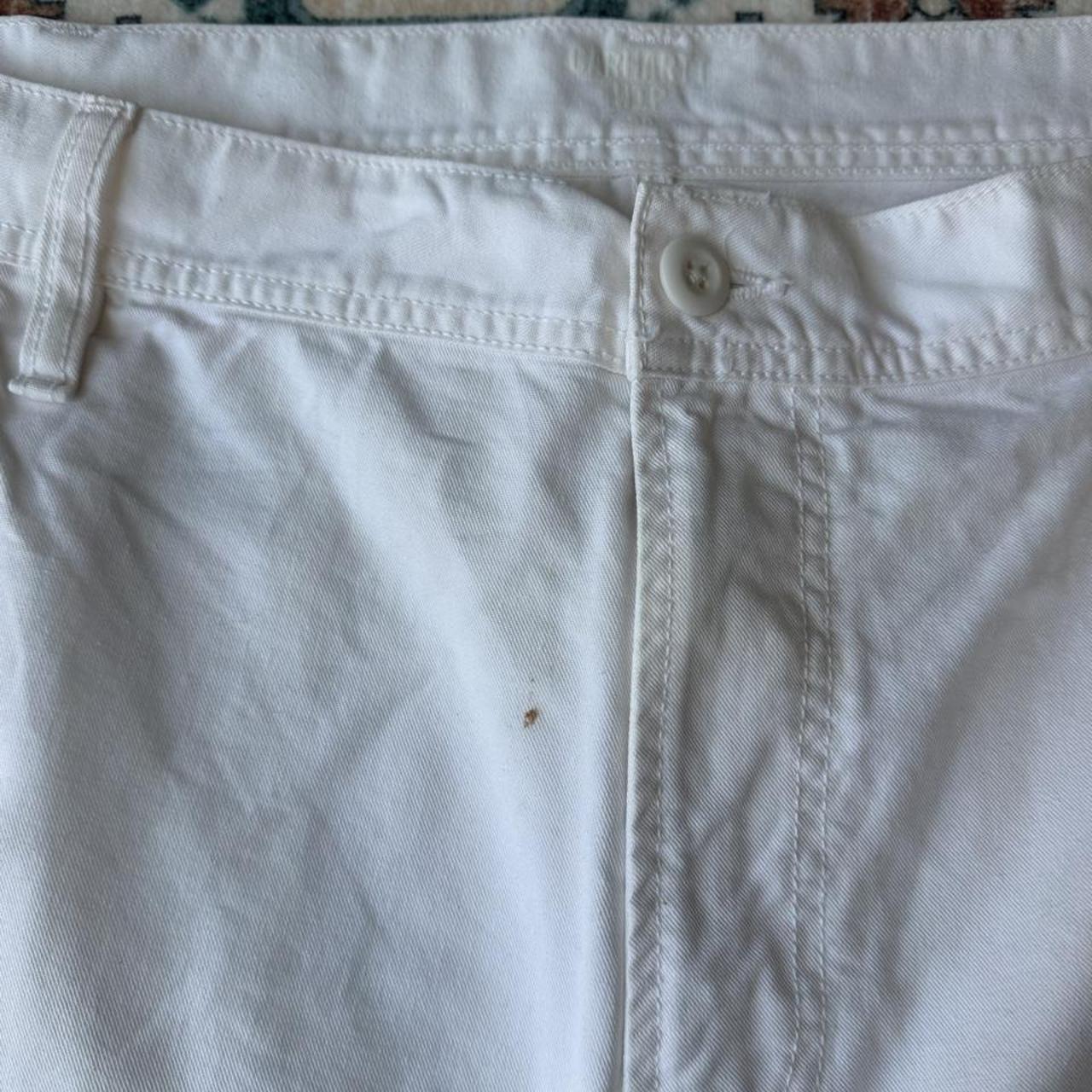 Carhartt WIP white shorts with slight yellowing, featuring classic logo and durable fabric.