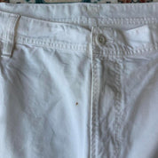 Carhartt WIP white shorts with slight yellowing, featuring classic logo and durable fabric.