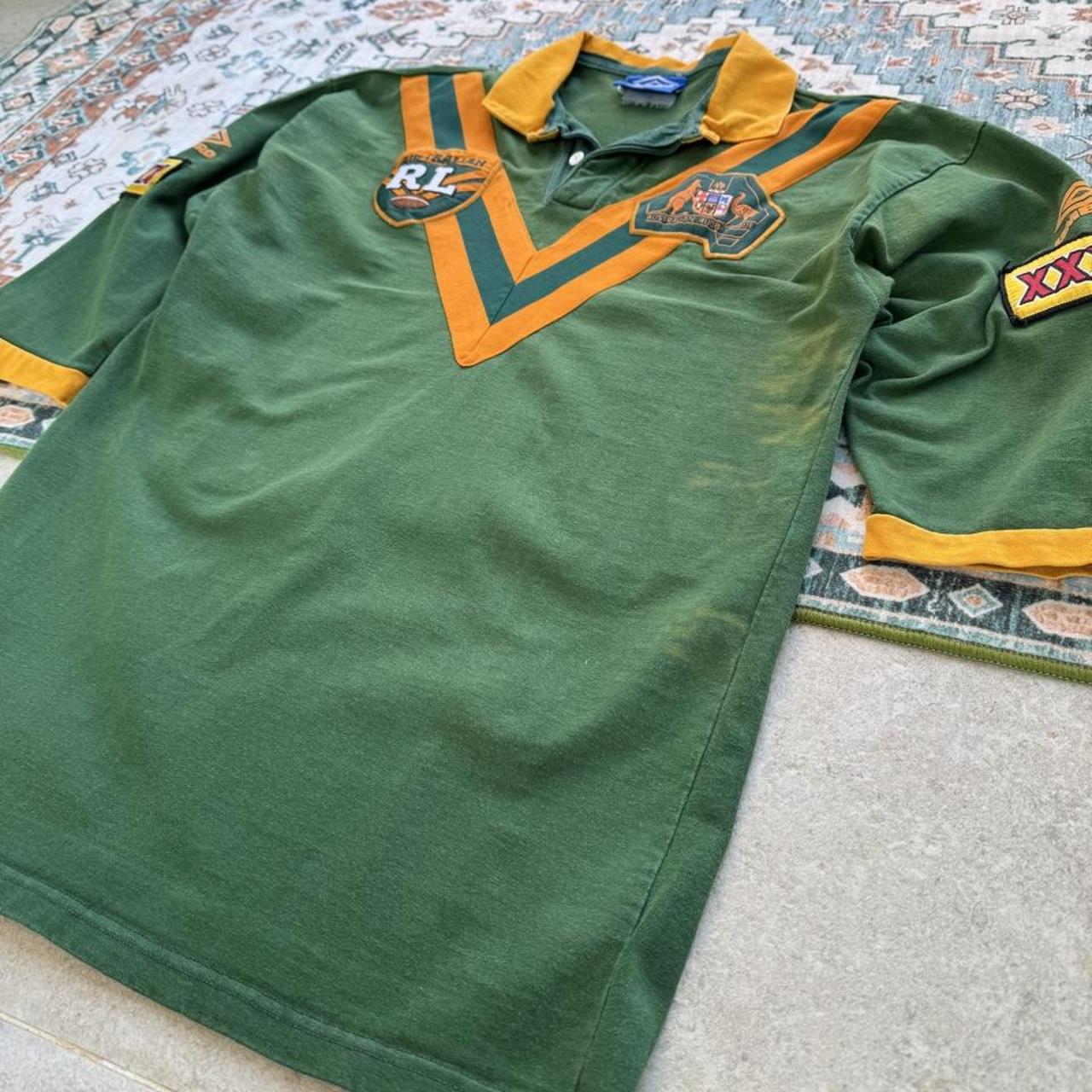 Umbro men's polo shirt green with Wallabies logo and rugby league pattern.