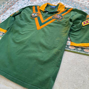 Umbro men's polo shirt green with Wallabies logo and rugby league pattern.