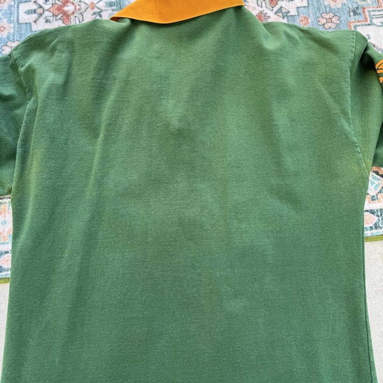 Umbro men's polo shirt green with Wallabies logo and rugby league pattern.