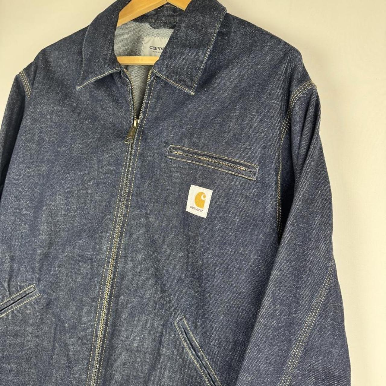 Carhartt WIP blue denim jacket with logo patch and classic design details.
